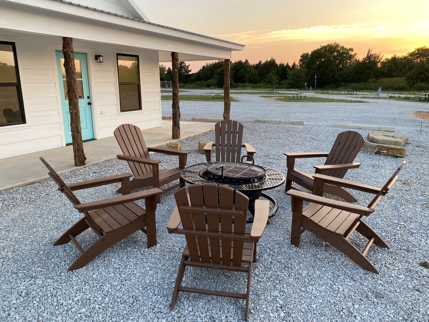 Community fire pit with Adirondack chairs at sunset at Roadrunner Ranch RV Resort near WinStar Casino