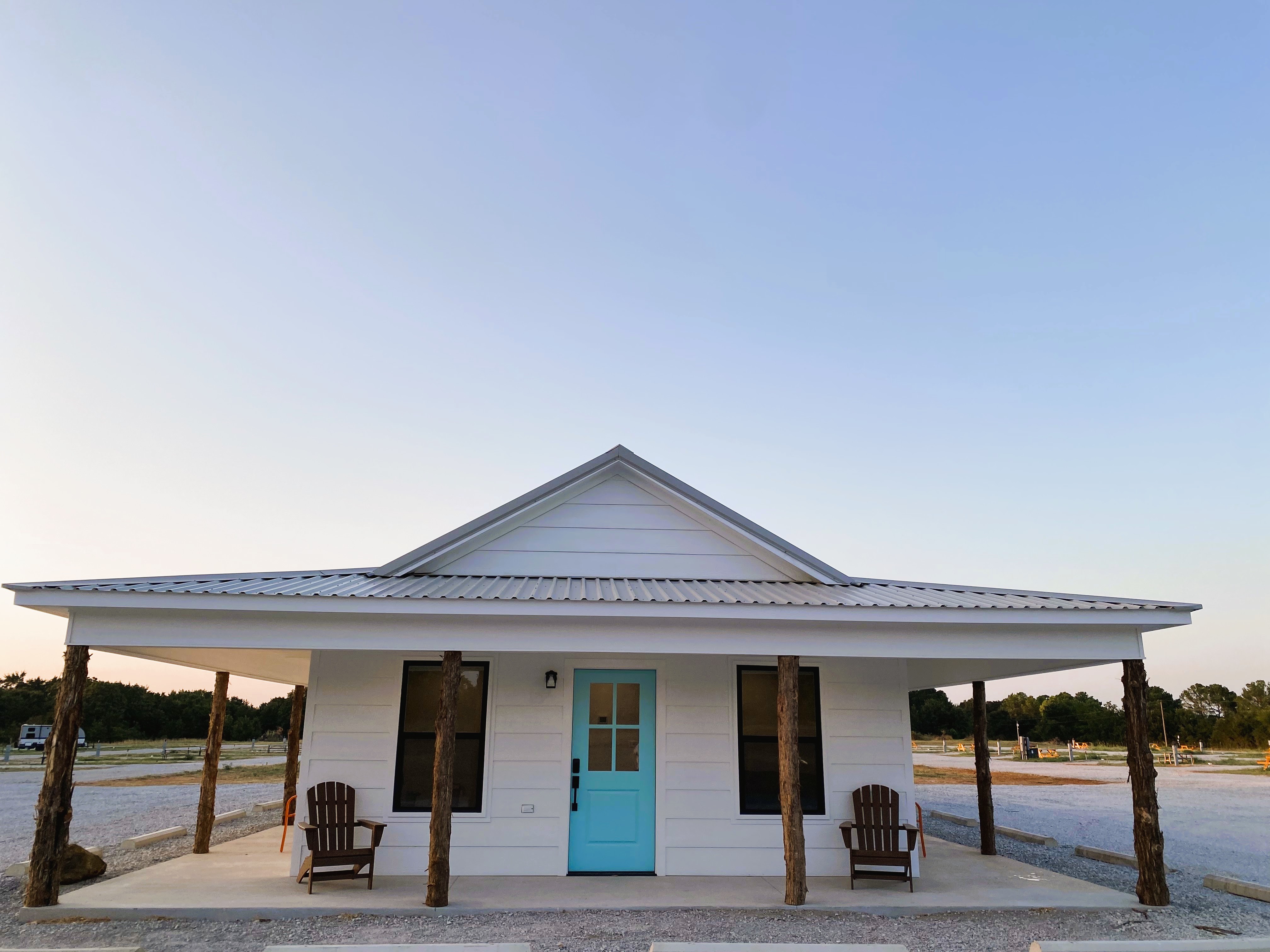 Front view of luxury shower suites building with turquoise door and covered porch at Roadrunner Ranch RV Resort