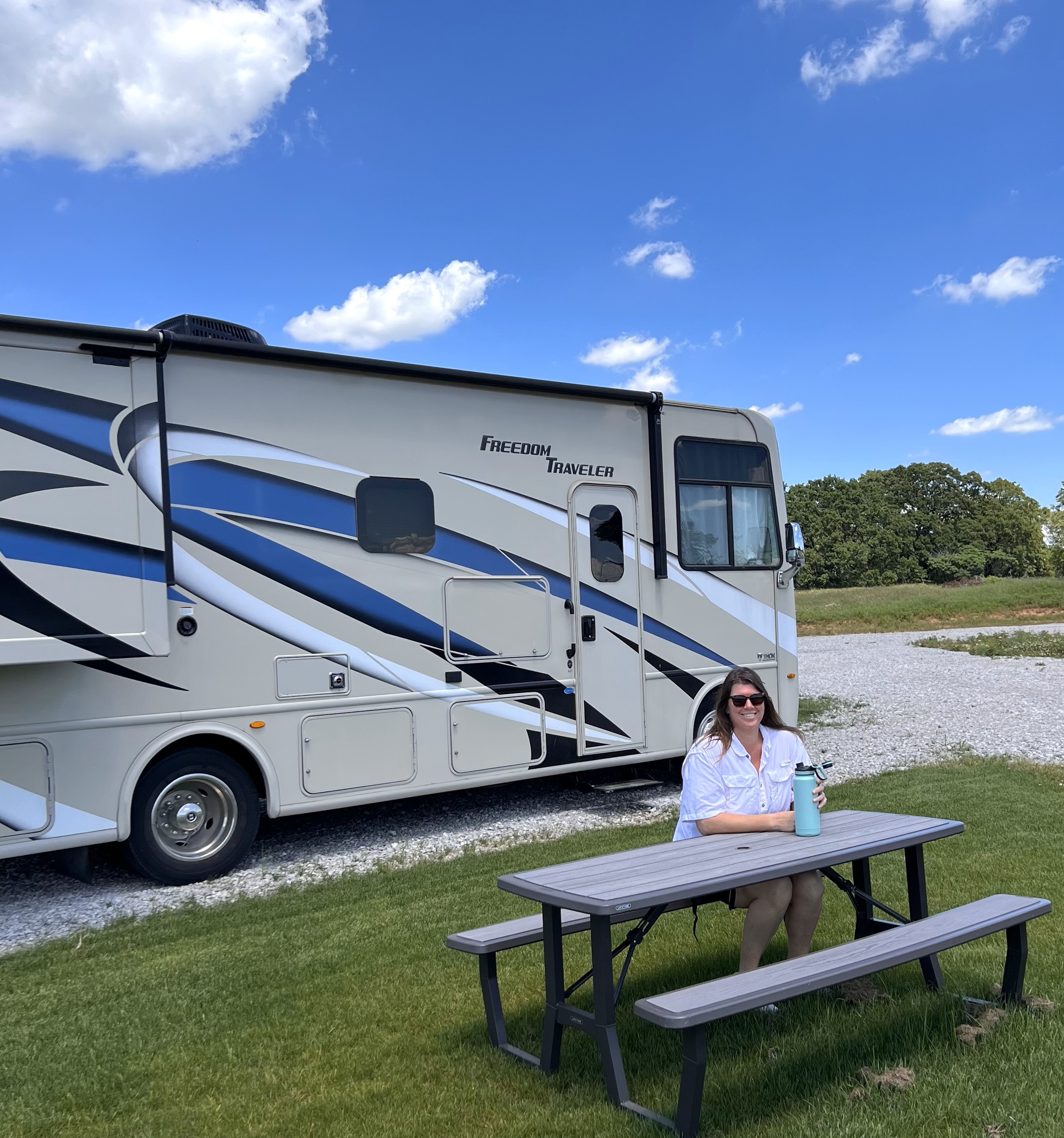 Guest relaxing at picnic table with RV at Roadrunner Ranch RV Resort Marietta Oklahoma